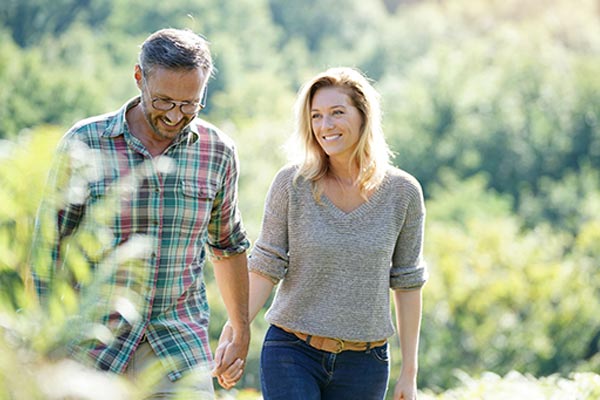 Happy Mature Couple Walking Through Park