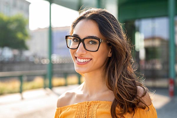 young woman big smile glasses