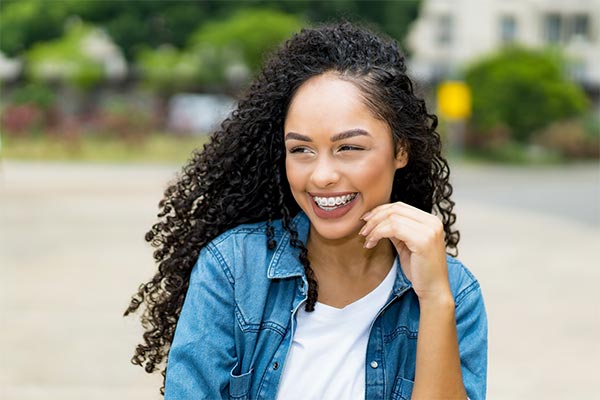 young woman smiling outside wearing braces